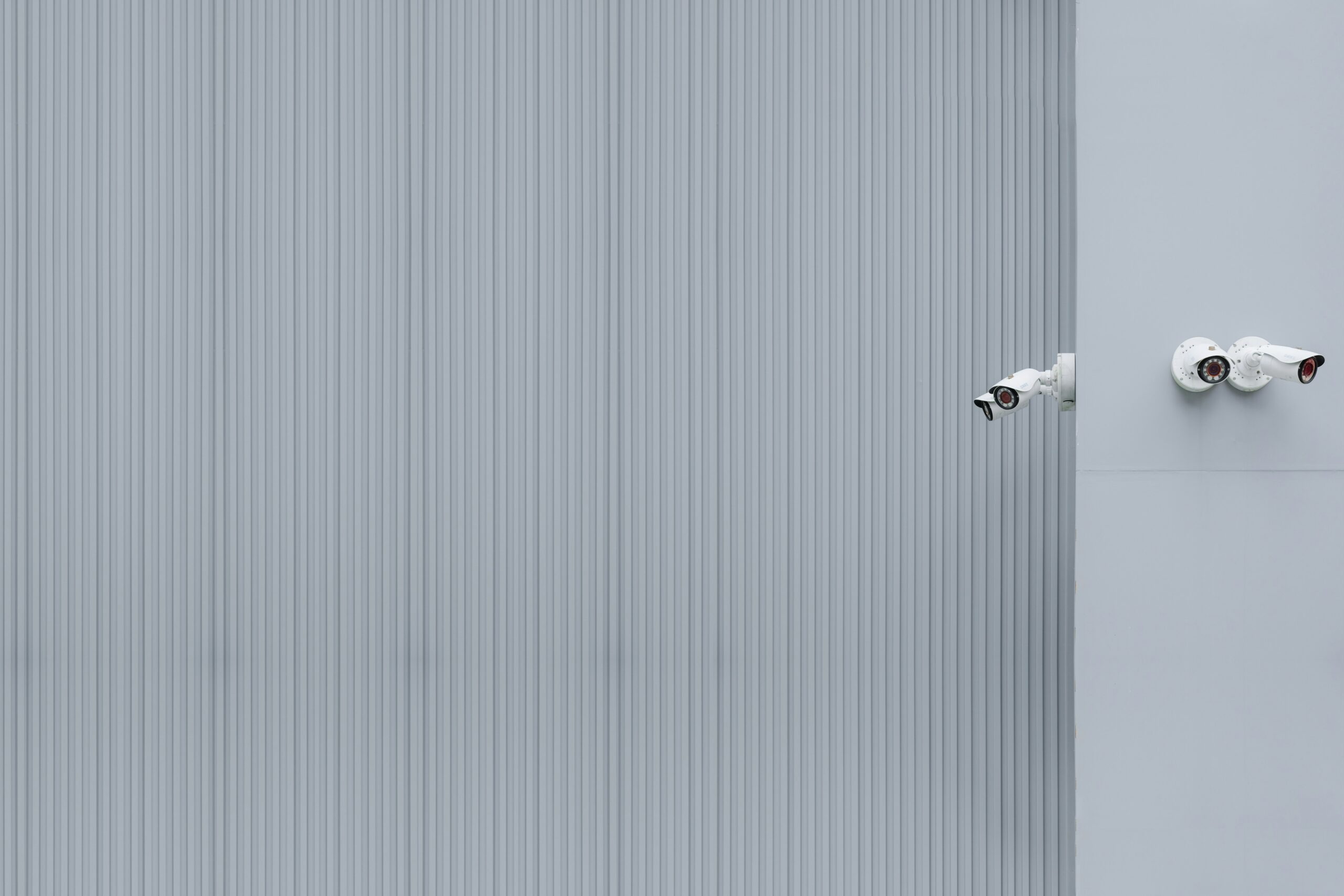 Security cameras on white wall