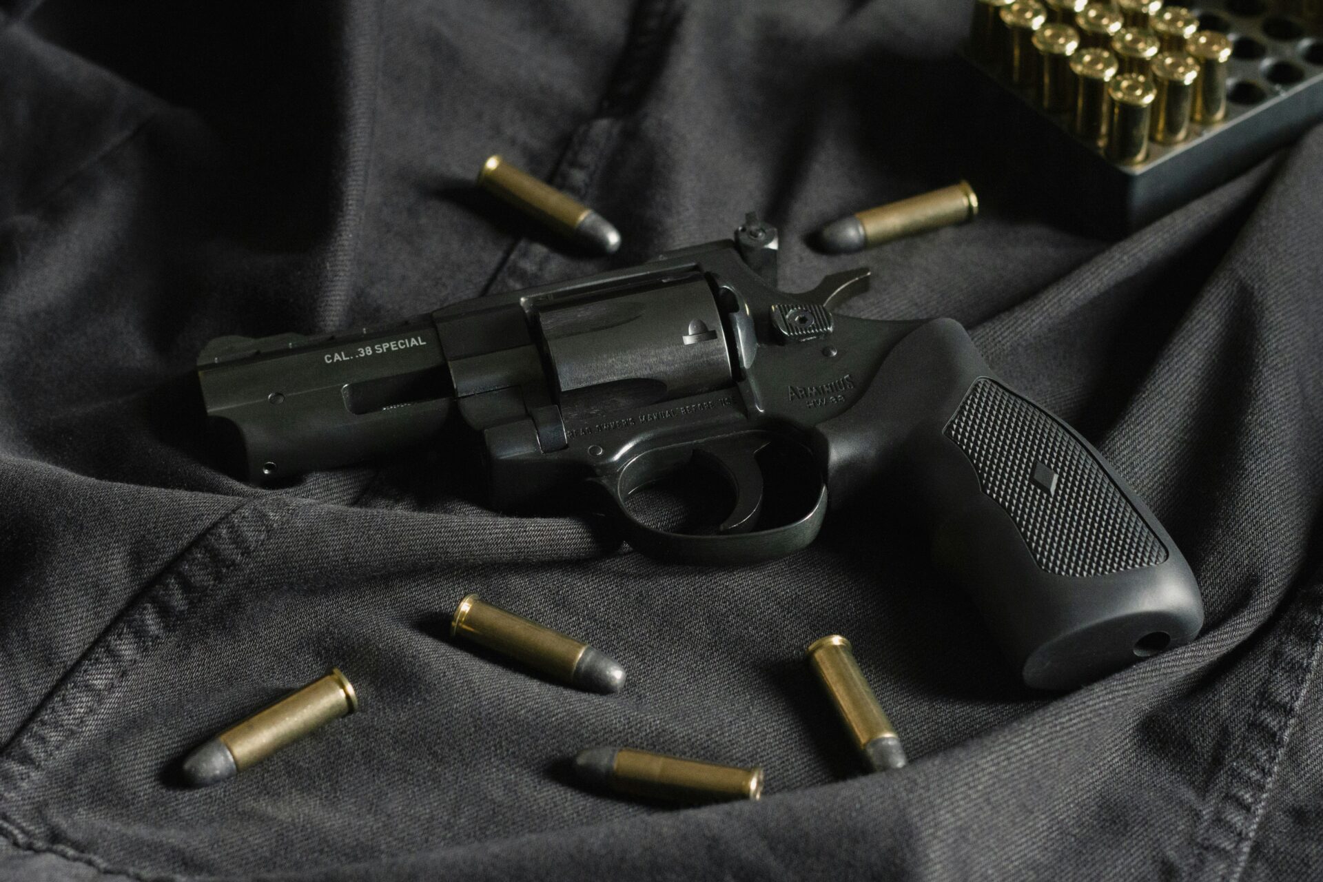 gun with bullets laying on cloth