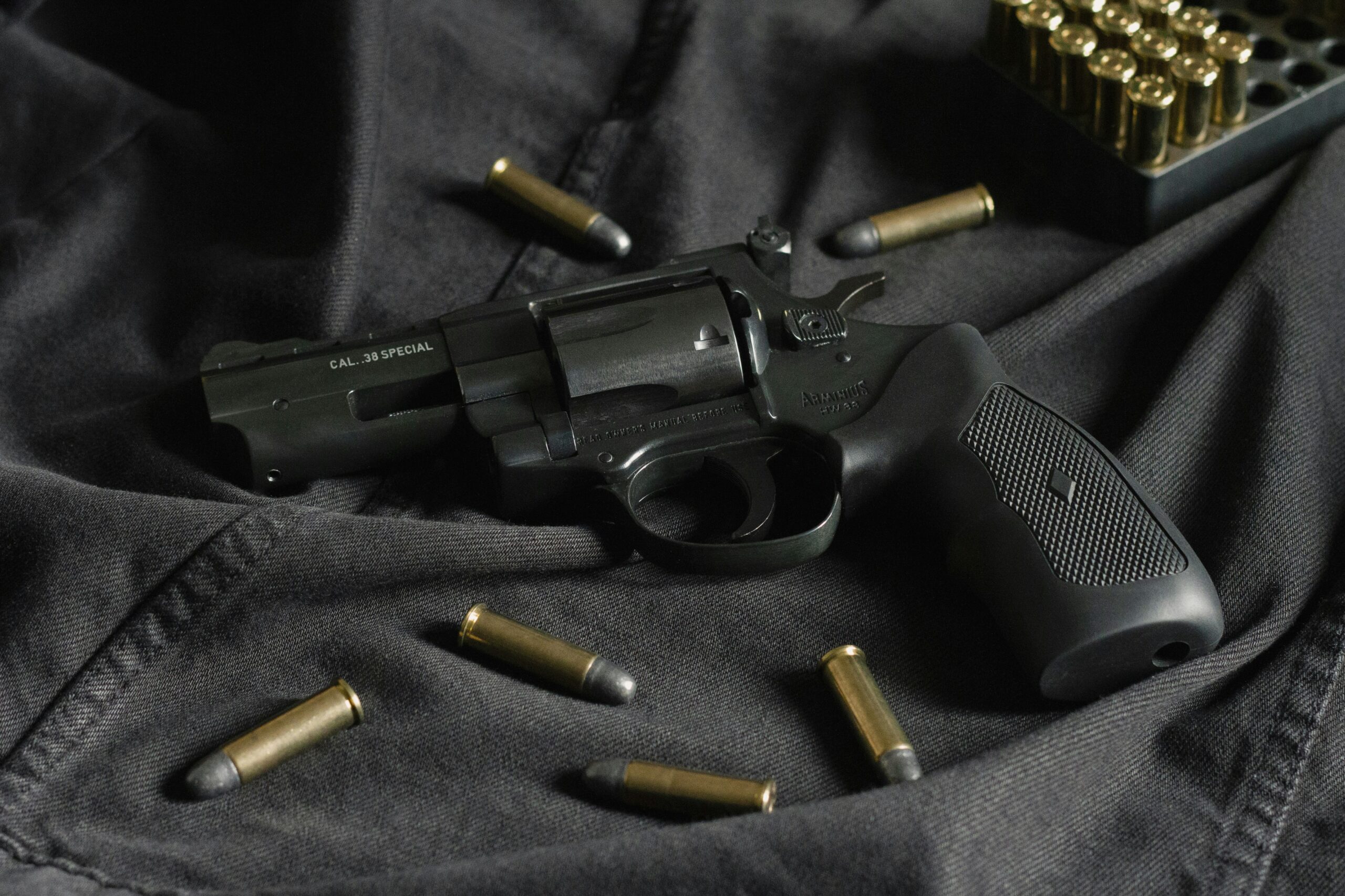 gun with bullets laying on cloth